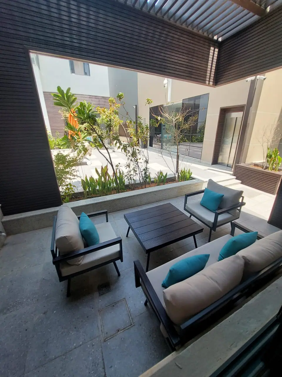Private terrace with outdoor sofas and planting at a Fay Compound villa